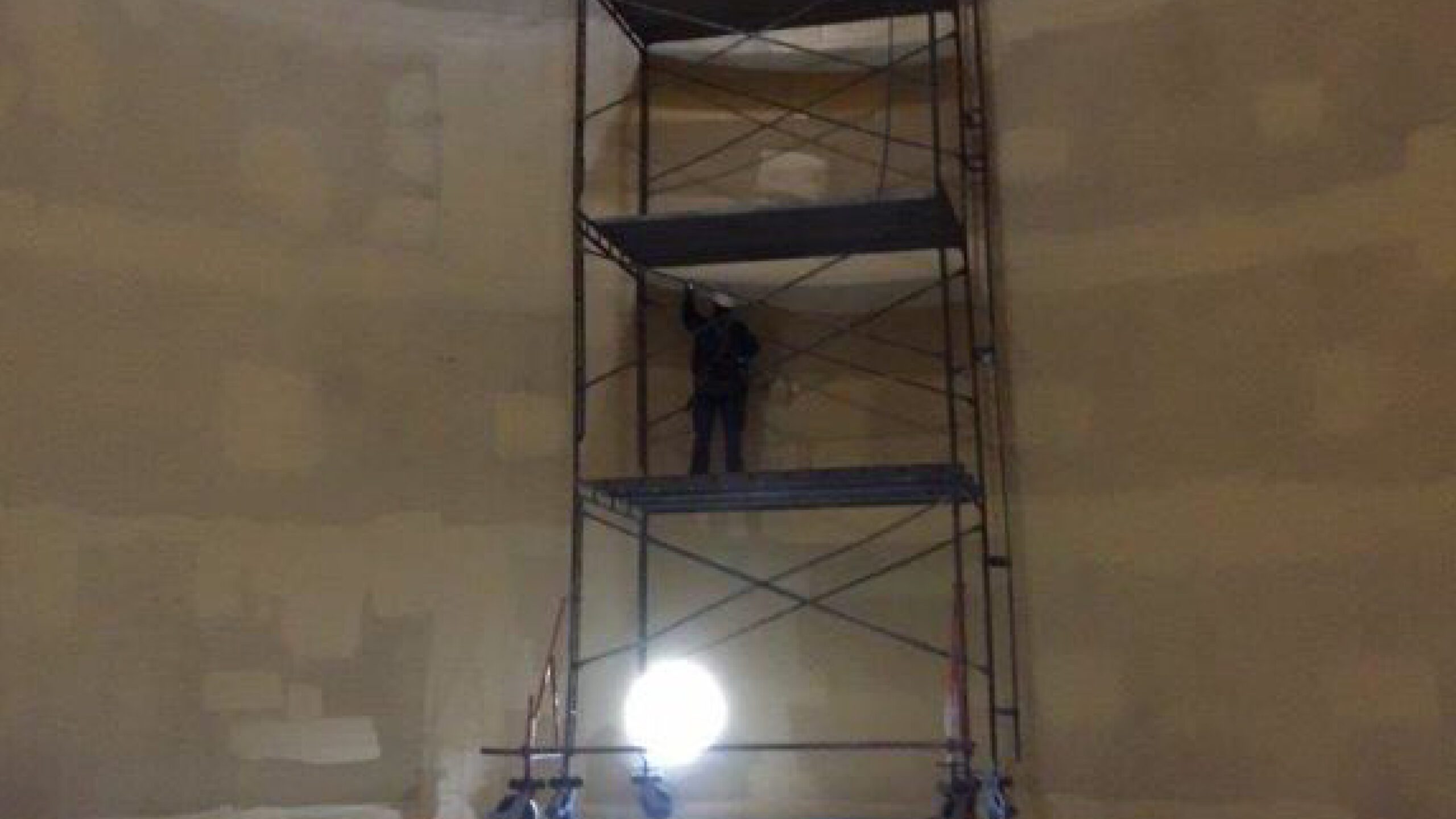 Man applying protective coatings and linings on the tank wall
