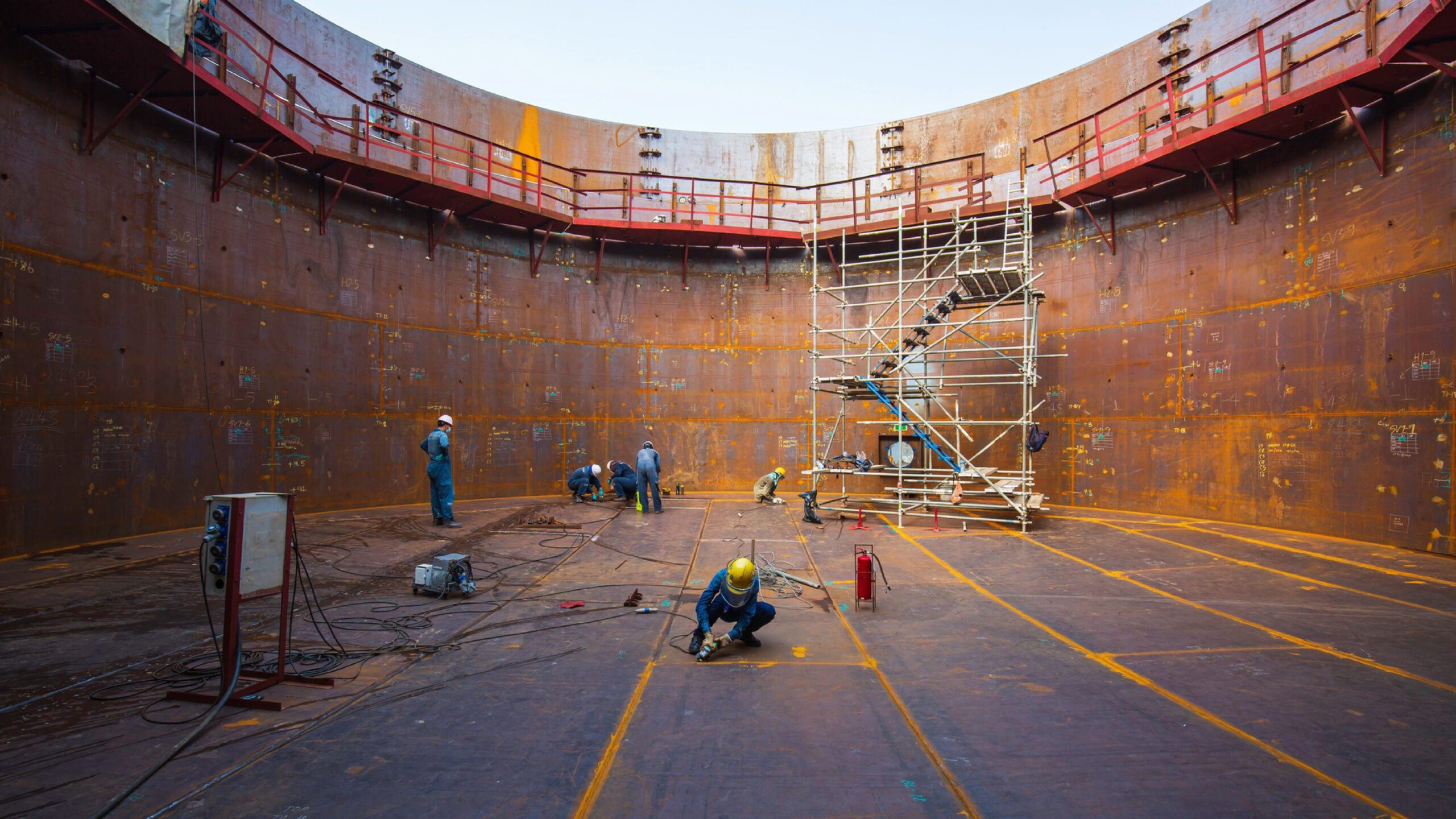 Male worker repairing the bottom plate of the tank